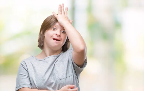 Young adult woman with down syndrome over isolated background surprised with hand on head for mistake, remember error. Forgot, bad memory concept.
