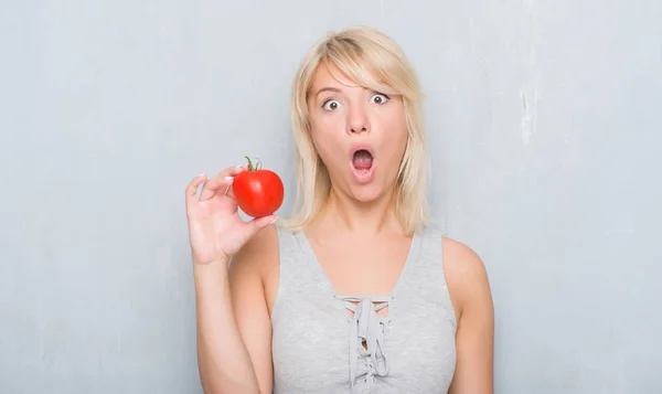 Mujer Caucásica Adulta Sobre Pared Gris Grunge Sosteniendo Tomate Fresco —  Fotos de Stock