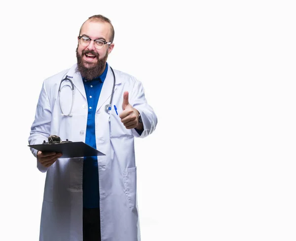 年轻的医生男子拿着剪贴板在孤立的背景高兴与大大的微笑做确定的迹象 用手指竖起大拇指 优秀的标志 — 图库照片