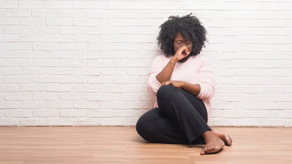 家の床の上に座って若いアフリカ系アメリカ人女性は 体調不良や風邪や気管支炎の症状として咳を感じてください ヘルスケアの概念 — ストック写真
