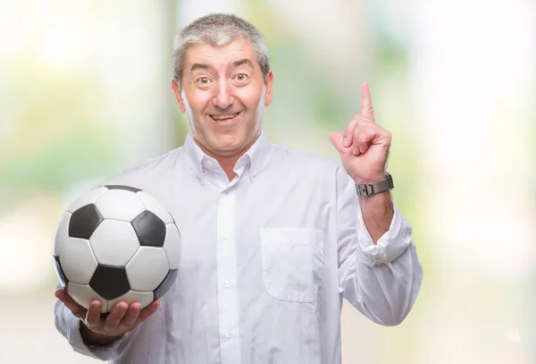 幸せそうな顔 ナンバーワンのアイデアや質問ポインティング指でびっくりの孤立した背景にサッカー サッカー ボールを保持しているハンサムな年配の男性 — ストック写真
