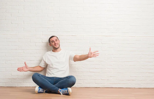 Kaukasische Jongeman Zittend Vloer Witte Bakstenen Muur Kijken Naar Camera — Stockfoto