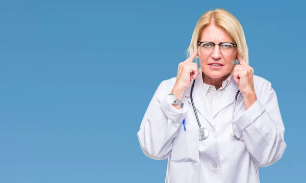 Médica Loira Meia Idade Sobre Fundo Isolado Cobrindo Orelhas Com — Fotografia de Stock