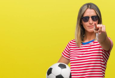 Futbol futbol topu tutan genç güzel kadın kamera ve size parmak ile işaret arka plan izole, el işareti, pozitif ve kendinden emin bir jest ön