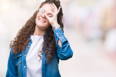 Güzel genç esmer kıvırcık saçlı kız gülümsüyor, parmakları ile mutlu yüz üzerinden seyir göz el ile ok jest yapıyor izole arka plan üzerinde gözlük.