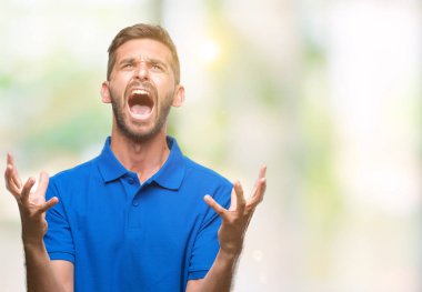 Genç yakışıklı adam izole arka plan çılgın ve kızgın bağırarak ve agresif ifade ve silah kaldırdı bağırıyor. Hayal kırıklığı kavramı.