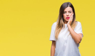 Genç güzel kadın acı ifadesi ile el ile ağız diş ağrısı veya dişlerde dişlerle ilgili hastalık nedeniyle izole arka plan dokunmadan üzerinde rahat beyaz t-shirt. Diş hekimi kavramı.