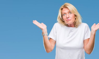Orta yaş sarışın kadın izole arka plan clueless ve şaşkın bir ifadeyle kollar ve eller kaldırdı. Şüphe kavramı.