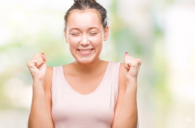 Kızgın ve silah ile başarı için deli kutluyor izole arka plan üzerinde beyaz genç güzel kadın kaldırdı ve heyecanlı çığlık gözler kapalı. Kazanan kavramı