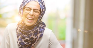 Kendinden emin ve mutlu bir büyük doğal gülümseme gülmek ile hijab giyen orta yaş Müslüman Arap kadın