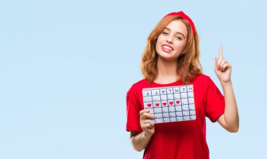 İzole arka plan adet takvim sürpriz bir fikir ya da soru işaret parmağı ile gülen yüz, bir numara tutan genç güzel kadın