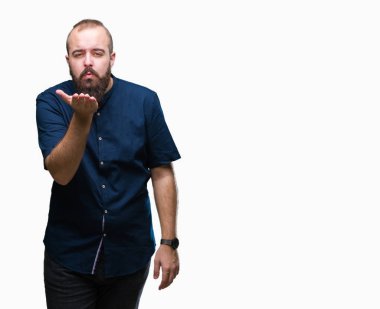 Genç beyaz hipster adam izole arka plan bir öpücük el ile güzel ve seksi olmak hava üfleme kamera bakıyor. Aşk ifade.