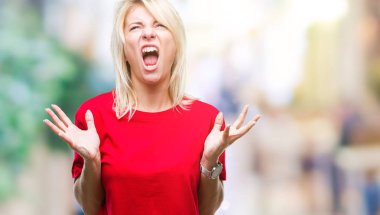 Üzerinde kırmızı t-shirt giyen genç güzel sarışın kadın arka plan deli izole ve deli bağırarak ve agresif ifade ve silah kaldırdı bağırıyor. Hayal kırıklığı kavramı.