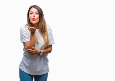 Casual beyaz t-shirt üzerine bir öpücük el ile güzel ve seksi olmak hava üfleme kamera bakarak arka plan izole genç güzel kadın. Aşk ifade.