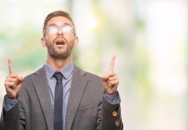 Genç yakışıklı iş adamı izole arka plan üzerinden hayran ve yukarıya bakıp parmakları ile işaret şaşırttı ve silah kaldırdı.