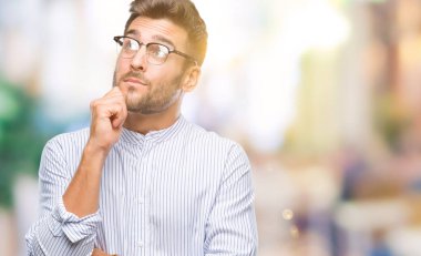 Yakışıklı delikanlı çene düşünme hakkında soru, dalgın ifade üzerine el ile izole arka plan üzerinde. Düşünceli yüzüyle gülümsüyor. Şüphe kavramı.