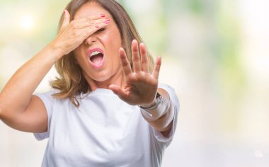 Orta yaş üst düzey İspanyol kadın izole elleriyle gözlerini kapsayan arka plan ve stop jest ile acı ve korku ifadesi. Utandım ve negatif kavramı.