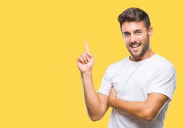 Kameraya bakarak yan el ve parmak ile işaret eden genç yakışıklı adam yüzünde kocaman bir gülümseme ile izole arka plan üzerinde.