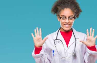 Genç afro Amerikalı doktor kadın gösterilen ve parmakları ile işaret izole arka plan yüzünden kendinden emin ve mutlu gülümseyerek süre on numara.