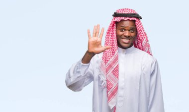 Geleneksel keffiyeh gösterilen ve parmakları ile işaret izole arka plan üzerinde giyen genç Arapça Afrika adam kendinden emin ve mutlu gülümseyerek süre beş numara.