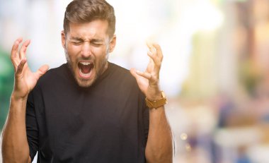 Genç yakışıklı adam kızgın ve silah ile başarı için deli kutluyor izole arka plan üzerinde kaldırdı ve heyecanlı çığlık gözler kapalı. Kazanan kavramı