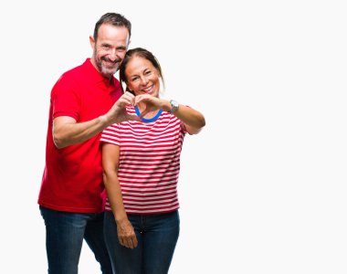 Orta yaş İspanyol çift aşık kalp simgesi ve elleriyle şekil gösteren gülümseyen izole arka plan üzerinde aşık. Romantik kavramı.