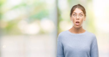 Çörek bir sürpriz yüz, korkuyor ve heyecanlı korku ifadesi ile şok korkmuş giyen genç güzel İspanyol kadın