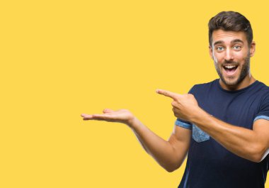 Yakışıklı delikanlı üzerinden hayran ve el ile sunulması ve parmak ile işaret ederken kameraya gülümseyen izole arka plan.