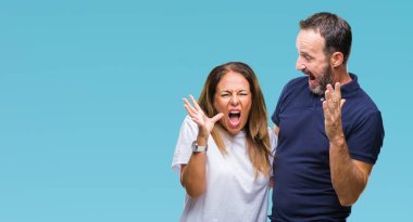 İzole arka plan çılgın ve kızgın bağırarak ve agresif ifade ve silah kaldırdı bağırmaya orta yaş İspanyol rahat bir çift. Hayal kırıklığı kavramı.