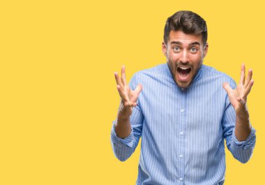 Yakışıklı delikanlı deli kutluyor ve silah ile başarı için heyecanlı çığlık kaldırdı ve açık gözleri hayret izole arka plan üzerinde. Kazanan kavramı