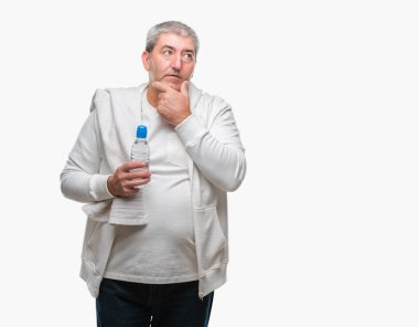 Yakışıklı komuta sizde eğitim holding havlu ve izole arka plan ciddi bir yüz düşünme hakkında soru, çok karışık bir fikir üzerinde su şişesi