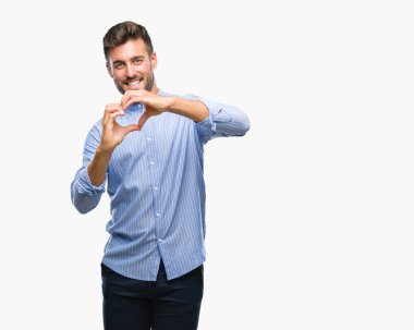 Yakışıklı delikanlı aşık kalp simgesi ve elleriyle şekil gösteren gülümseyen izole arka plan üzerinde. Romantik kavramı.