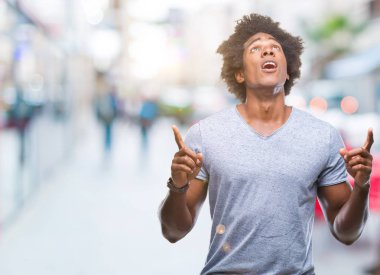 Afro Amerikalı adam izole arka plan üzerinden hayran ve yukarıya bakıp parmakları ile işaret şaşırttı ve silah kaldırdı.