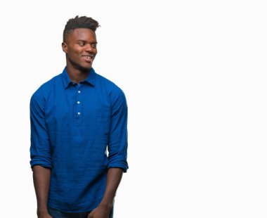 Afrikalı-Amerikalı genç uzak tarafına yüzünde, doğal ifade gülümseme ile seyir izole arka plan üzerinde. Kendine güvenen gülüyor.