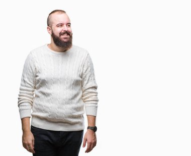 Üzerinde kış kazak giyen genç beyaz hipster adam arka plan uzak tarafına gülümseme ile yüzünde, doğal ifade arıyorum izole. Kendine güvenen gülüyor.