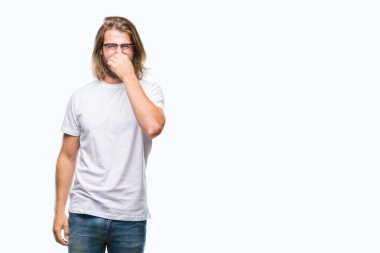 Genç yakışıklı adam uzun saçlı gözlüklü bir şey pis ve iğrenç kokulu izole arka plan, dayanılmaz koku, holding nefes burun parmaklar ile. Kötü kokuyor kavramı.