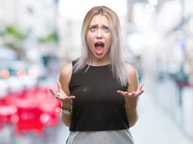 Sarışın genç kadın izole arka plan çılgın ve kızgın bağırarak ve agresif ifade ve silah kaldırdı bağırıyor. Hayal kırıklığı kavramı.