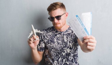 Aircraf tutarak ve tatil üzerinde pass yatılı genç Kızıl saçlı adam 