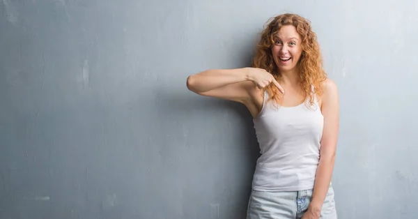 Junge Rothaarige Frau Über Graue Grunge Wand Mit Überraschendem Gesicht — Stockfoto