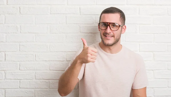 Joven Hombre Caucásico Pie Sobre Pared Ladrillo Blanco Con Gafas —  Fotos de Stock