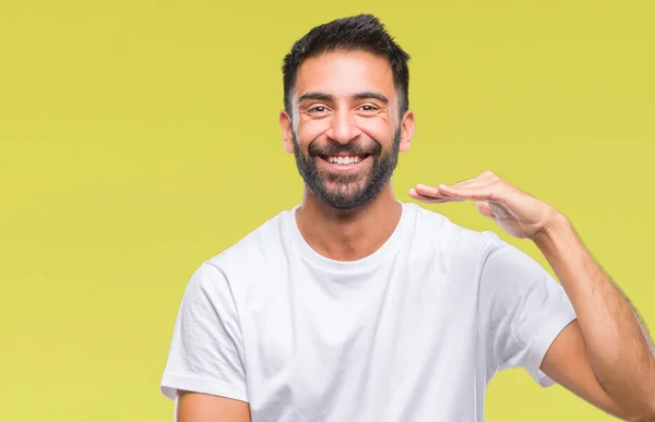 成年西班牙裔男子在孤立的背景手势与手显示大和大尺寸标志 测量符号 微笑着看着相机 测量概念 — 图库照片