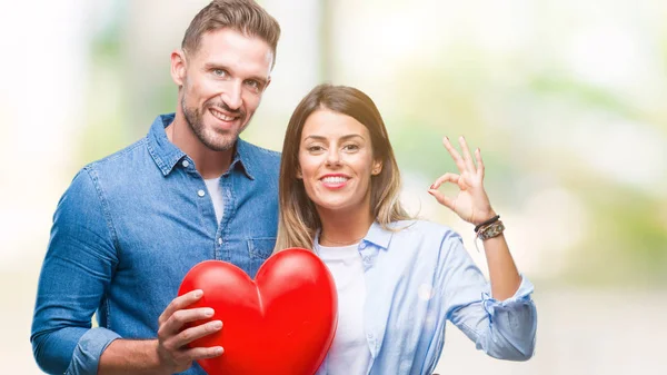 Jovem Casal Apaixonado Segurando Coração Vermelho Sobre Fundo Isolado Fazendo — Fotografia de Stock