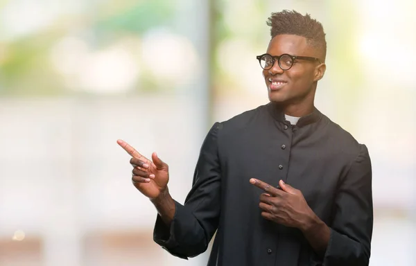 Junger Afrikanisch Amerikanischer Priester Über Isoliertem Hintergrund Lächelt Und Blickt — Stockfoto