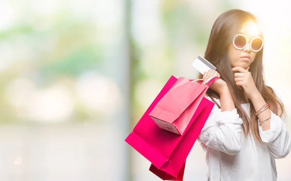 販売に関する質問は 非常に混乱して考え分離背景深刻な顔を考えての上レジ袋を保持している若いアジア女性 — ストック写真