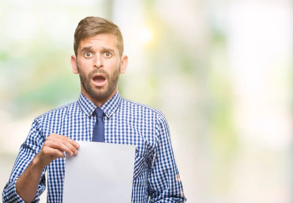 Jovem Homem Bonito Segurando Papel Branco Sobre Fundo Isolado Assustado — Fotografia de Stock