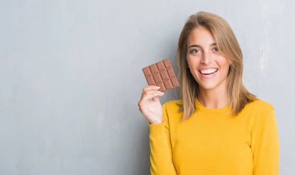 Schöne Junge Frau Über Grunge Grey Wall Eating Chocolate Bar — Stockfoto