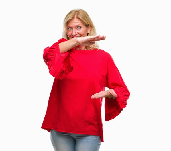 中年金发女人在孤立的背景手势与手显示大和大尺寸标志 测量符号 微笑着看着相机 测量概念 — 图库照片