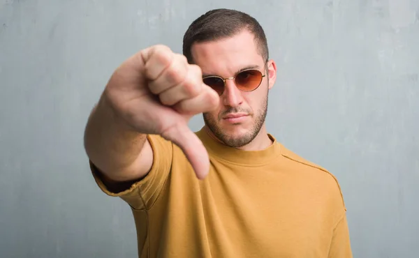 Homem Caucasiano Jovem Sobre Parede Grunge Cinza Usando Óculos Sol — Fotografia de Stock