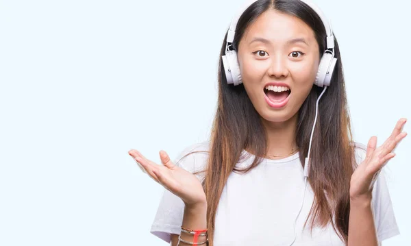 身に着けているヘッドフォン分離背景非常に幸せと興奮 勝者式祝う勝利笑顔で叫び 手を上げた音楽を聴く若いアジア女性 — ストック写真