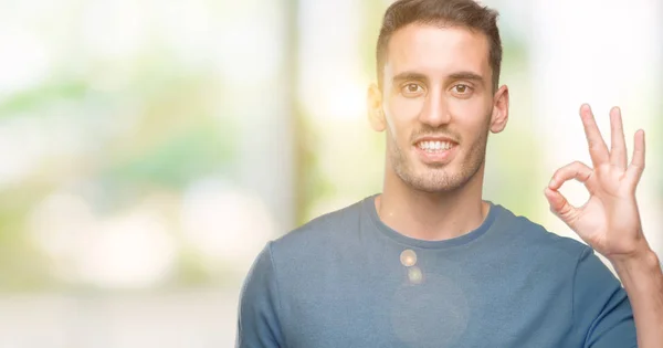 Guapo Joven Casual Hombre Sonriendo Positiva Haciendo Signo Con Mano —  Fotos de Stock